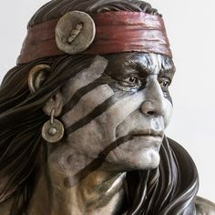 a close up of a statue of a man with black and white stripes on his face