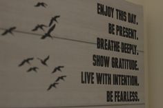 there is a sign with birds on it that says enjoy this day be present breathe deeply show gratitue live with intention be fearless