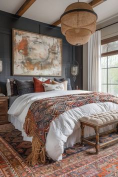 a large bed sitting under a painting on top of a wooden floor next to a window