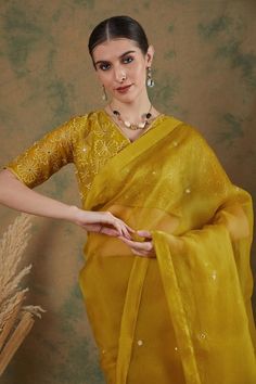 Golden yellow silk organza saree with mirror embroidery. Comes with thread embroidered blouse.
Components: 2
Pattern: Embroidered
Type Of Work: Mirror, Floral
Neckline: V Neck
Sleeve Type: Half
Fabric: Silk organza
Color: Gold,Yellow
Other Details: 
Note: Petticoat worn by the model is not for sale.
Occasion: Wedding - Aza Fashions Embroidered Organza Blouse For Diwali, Diwali Embroidered Organza Blouse, Festive Bollywood Organza Blouse, Yellow Anarkali Style Pre-draped Organza Saree, Yellow Organza Pre-draped Saree For Eid, Navratri Embroidered Organza Blouse, Bollywood Style Embroidered Organza Blouse, Festive Organza Saree Blouse, Yellow Organza Pre-draped Saree For Party