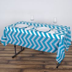 a blue and white zigzag tablecloth with two wine glasses on it