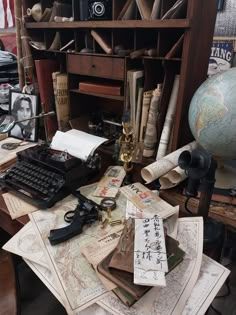 an old typewriter sitting on top of a desk covered in books and other items