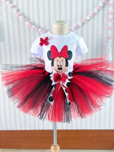 a red and black minnie mouse tutule dress on a mannequin stand