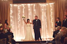 a bride and groom are standing at the end of their wedding ceremony as guests look on