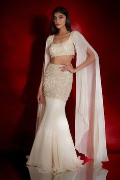 Ivory mermaid lehenga featuring sequin,bead and crystal cluster embroidered waistline. Comes with embellished cape sleeve blouse. - Aza Fashions Mermaid Skirt Outfit Indian, Blouse With Cape Sleeves, Blouse Designs Western Look, Fish Lehenga Style, Pearl Indian Outfit, Fish Cut Lehenga Designs, Fish Cut Lehenga Indian, Fish Cut Gown Indian, Pooja Outfit Indian