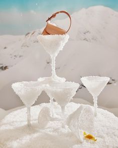 three martini glasses are sitting in the snow