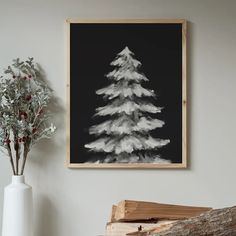 a black and white christmas tree is hanging on the wall next to a vase with red berries