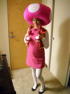 a woman in a pink dress and mushroom hat