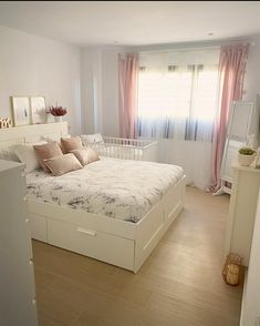 a bedroom with a bed, dressers and mirror in it's center area