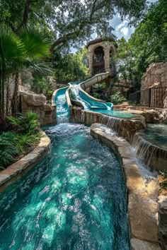 a water slide in the middle of a pool surrounded by lush green trees and plants