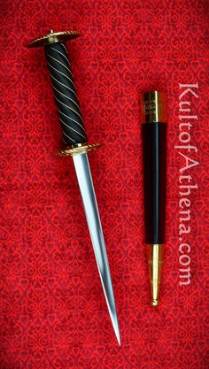 a black and gold pen sitting next to a knife on top of a red cloth