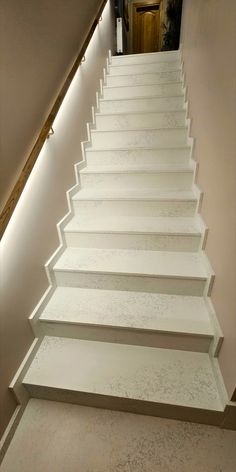 a set of white stairs leading up to a door with lights on the bottom and bottom