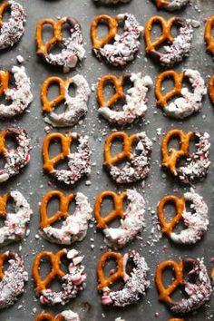 many pretzels are covered with sprinkles and powdered sugar on a baking sheet