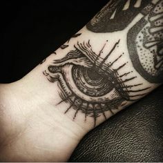 a person's arm with an eye tattoo on it