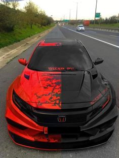 an orange and black car on the road