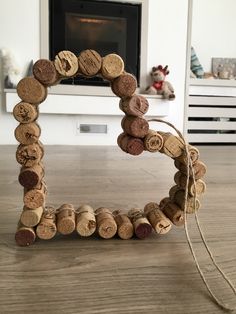 a frame made out of wine corks sitting on top of a wooden floor next to a fireplace