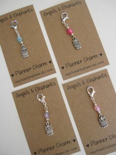 four charms with different designs on them sitting on top of a card that says planner charms