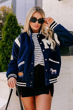 - This trendy varsity jack will surely steal the spotlight! - Fully lined warm material with black and white faux leather and sherpa accents - Features four accent patches - A black and white ribbed collar - A button front - Long, loose sleeves with black and white ribbed cuffs - Functional low pocket - A slouched silhouette that ends in a straight hemline with a ribbed texture Measurements S : Bust 50", Hip 42", Length 25", Sleeve Length 28.5", Waist 48". M : Bust 52", Hip 44", Length 25", Slee Winter Varsity Outerwear For Campus, Varsity Style Winter Campus Outerwear, Varsity Winter Outerwear For Campus, Winter Campus Outerwear With Baseball Collar, Trendy Varsity Jacket For Winter, Varsity Jacket With Button Closure For College, Winter Outerwear With Baseball Collar For Campus, College Style Winter Outerwear For Campus, Fall Varsity Jacket For Campus