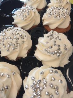 cupcakes with white frosting and silver decorations