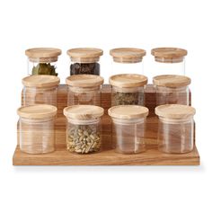 an assortment of spice jars with wooden lids