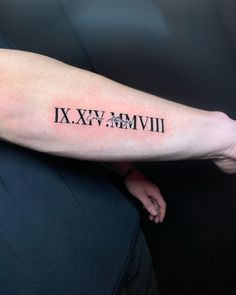 a man's arm with roman numerals tattooed on the upper half of his arm