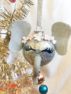 an ornament shaped like an elephant with wings and flowers on it's head