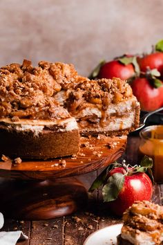 an apple crumb cake on a wooden platter with apples in the back ground