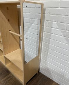 a white brick wall behind a wooden cabinet