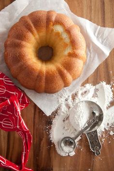 a bagel sitting on top of a wooden table next to some powdered sugar