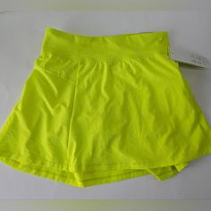 Secure Pockets Knit Waistband For Comfort Continuous Loop Drawstring For Adjustable Fit Inner Shorts Liner Stretch Playwear Shorts In Solid Color, Stretch Shorts For Playwear, Stretch Playwear Shorts, Casual Green Skort For Workout, Casual Green Skort For Sports, Casual Yellow Stretch Skort, Yellow Cotton Skort, Yellow Moisture-wicking Short Bottoms, Yellow Drawstring Shorts