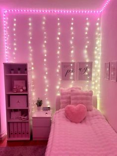 a bedroom decorated in pink and white with lights