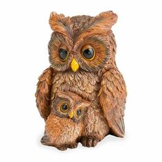 an owl figurine with its baby sitting next to it's parent on a white background