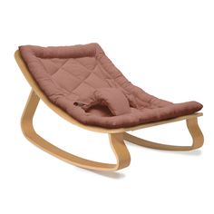 a wooden rocking chair with a pink cushion on it's back and seat pad