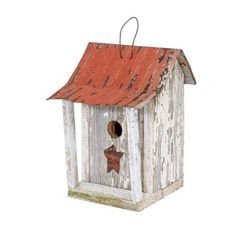 a bird house with a red roof and star decoration on the top is painted white