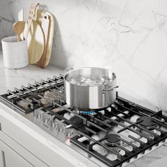 a pot sitting on top of a stove next to a pan and utensils