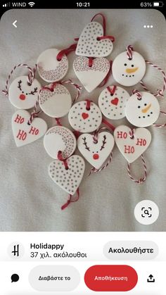 some heart shaped ornaments are hanging on a white sheet with red and white string attached to them