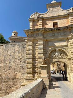 the entrance to an old stone building on a sunny day