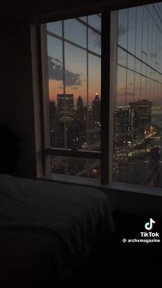 a bedroom with a view of the city at night