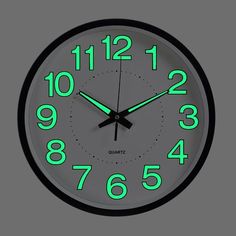 a black clock with neon green numbers on the front and side of it's face