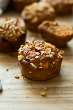 several muffins are sitting on a table with some oats scattered around them