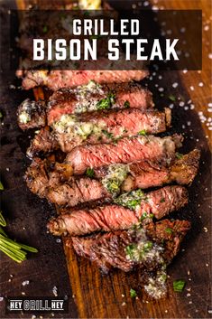 grilled bison steak on a cutting board with herbs and seasoning sprinkles