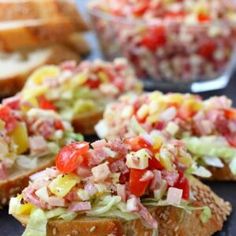 a sandwich with lettuce, tomato, and other toppings on it next to some bread