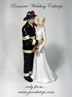 a wedding cake topper with a fireman and bride