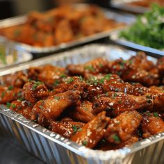 several tin pans filled with chicken wings and garnished with parsley on top