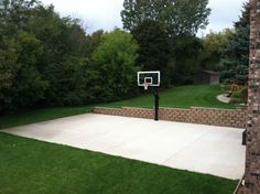 an outdoor basketball court in the middle of a yard