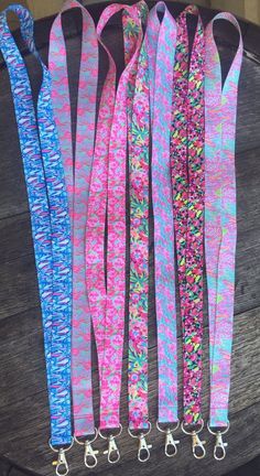 five different colored lanyards are lined up on top of a wooden table,