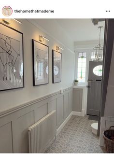 a hallway with pictures on the wall and a radiator in the corner next to it