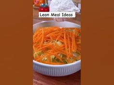 a bowl filled with shredded carrots on top of a wooden table