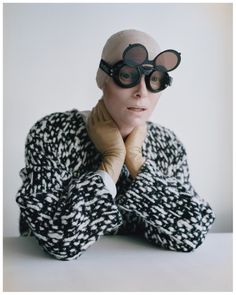 a woman wearing goggles and gloves with her hands on her chin, posing for the camera