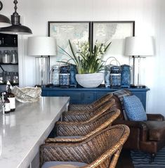 a living room filled with lots of furniture next to a counter top and two lamps